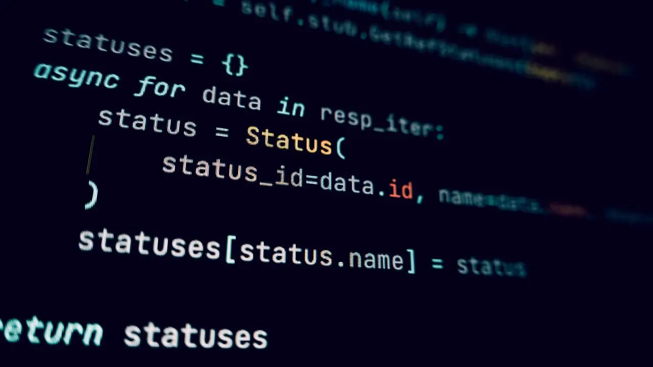 A full-stack web developer working on a laptop with code on the screen.